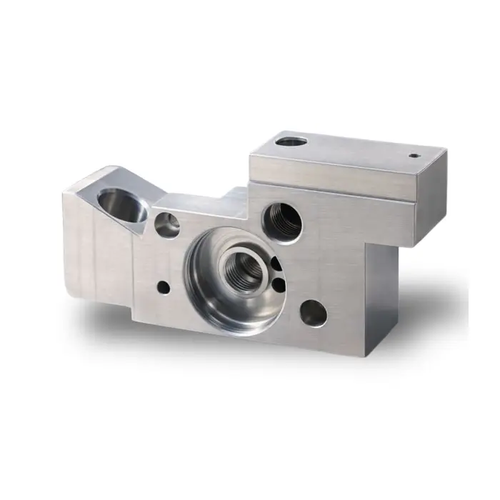 Custom machined components block featuring a precision bored main chamber and counterbored mounting holes.