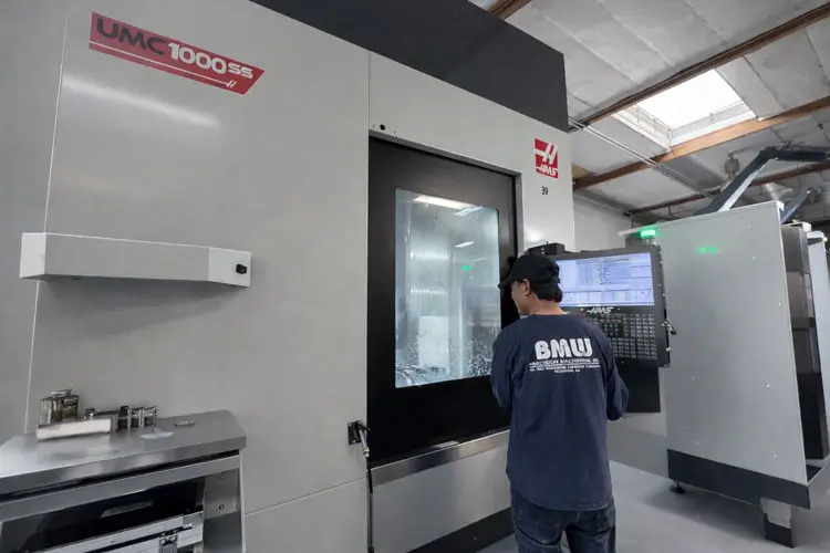High-precision Haas UMC-1000 5-axis CNC machining center processing complex aerospace and medical components.