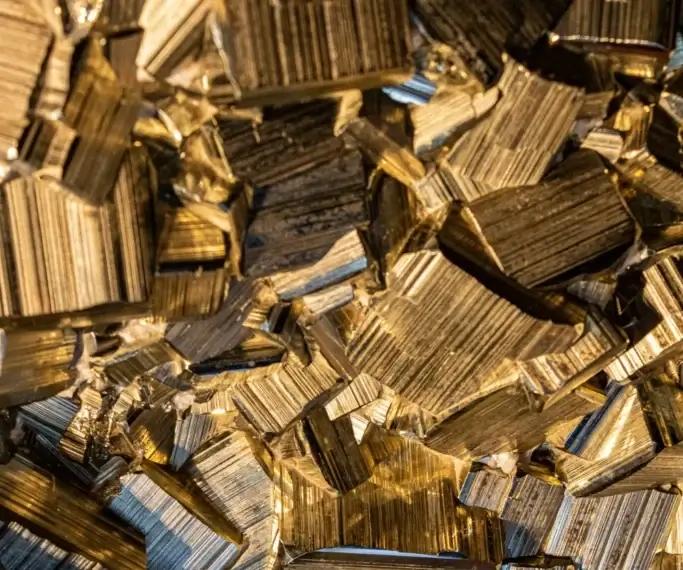 A detailed macro shot of raw golden brass alloy material blocks representing our custom material sourcing capabilities.