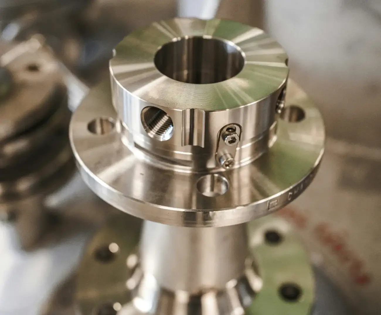 A high-precision CNC machined titanium component assembly showing intricate multi-axis milling and threaded holes.